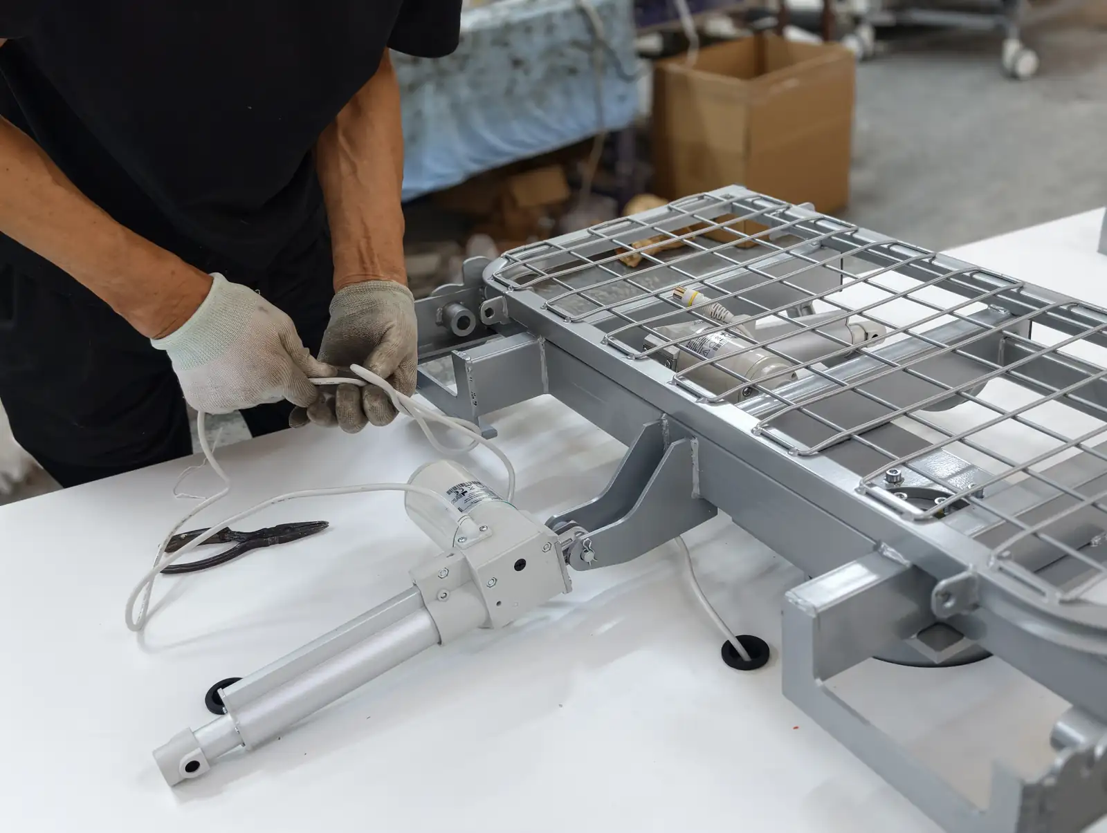 SHLION employee installing an electric actuator on a hospital bed platform